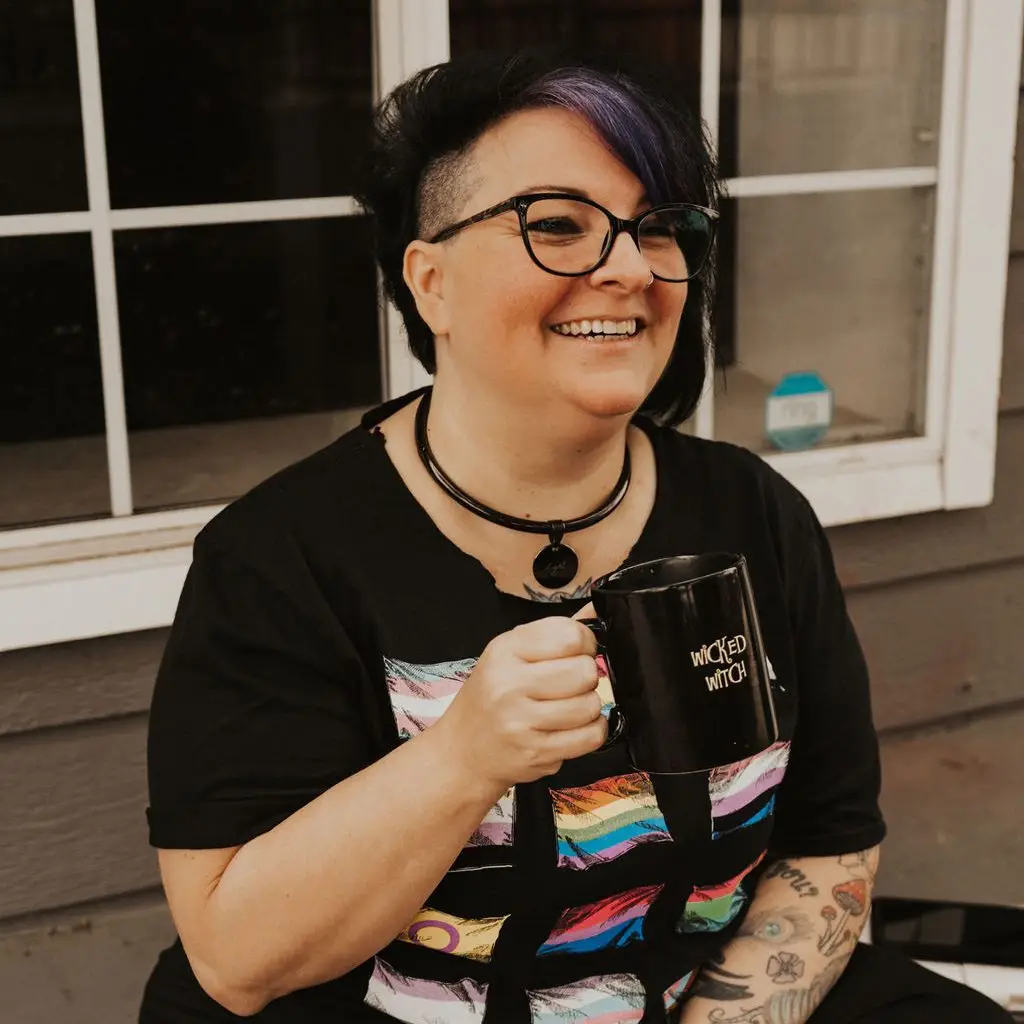 AJ Locashio smiling holding a coffee mug