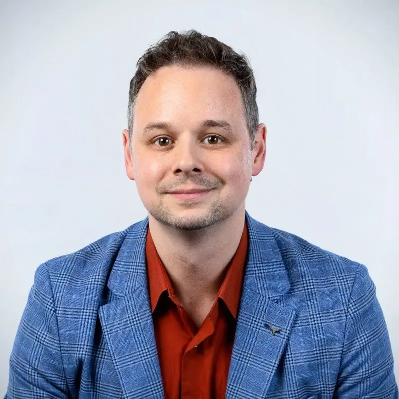 a person wearing a blue checkered blazer and a red shirt